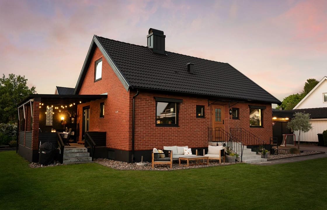 The uploaded listing photo: a brick house at dusk with an empty street